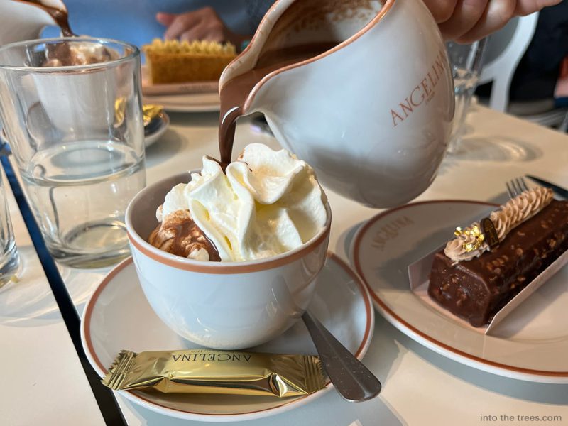 Pouring Angelina's hot chocolate into a cup of whipped cream.