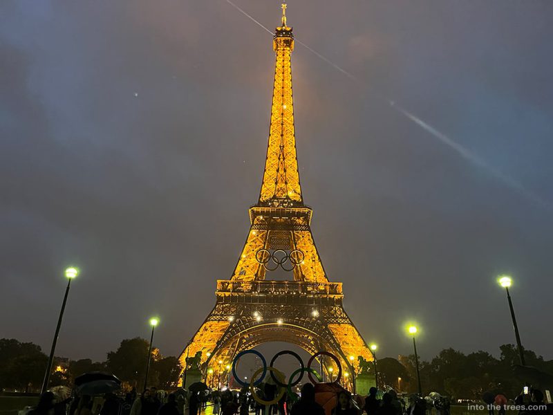 Eiffel tower lit up and sparkling at night.