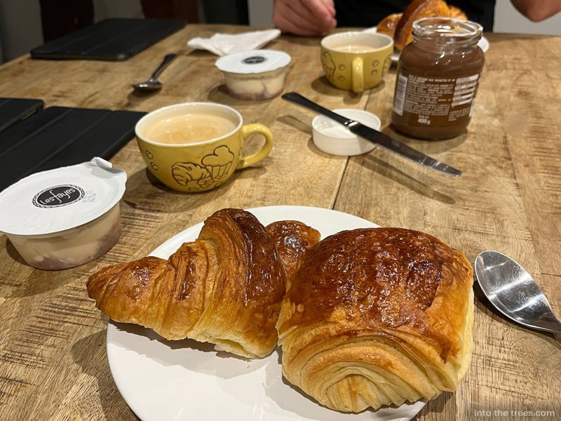Pastry on a plate with coffee cuups.